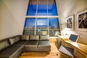 uma sala de estar com um sofá e uma grande janela em Apex City of Glasgow Hotel em Glasgow