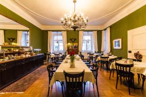 un comedor con mesas y sillas y una lámpara de araña en Boutique-Hotel Alter Gerichtshof, en Hartberg