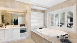 a large bathroom with a tub and a sink at The Vintage Manor in Pokolbin