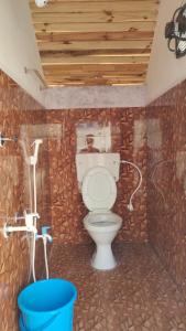 a bathroom with a toilet with a wooden ceiling at Starlit premium camps in Mahabalipuram