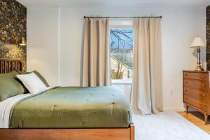 Schlafzimmer mit einem Bett und einem Fenster in der Unterkunft Charcoal Chalet by AvantStay A Design w Firepit in New Paltz