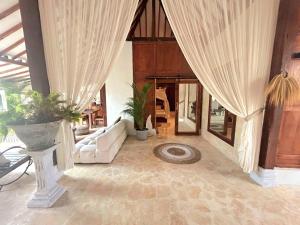 a living room with curtains and a white couch at BaraJade Villas in Uluwatu
