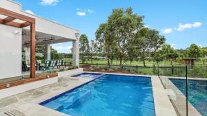 a swimming pool in the backyard of a house at Villa Tallawanta in Pokolbin
