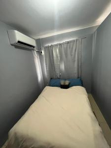 Habitación pequeña con cama y calentador en Butuan Cozy Riverhouse Transient, en Butuán