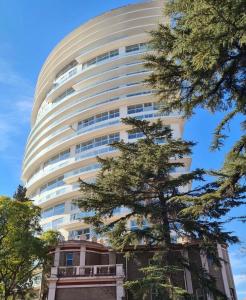 メンドーサにあるTorre Lの前に木がある高い建物