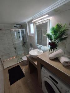 a bathroom with a sink and a washing machine at Giannis House 2 minutes walk to the beach Peroulia in Kómboi