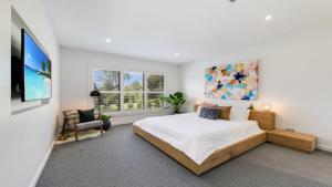 a bedroom with a large bed and a tv at Hunter Valley Wildflower in Pokolbin
