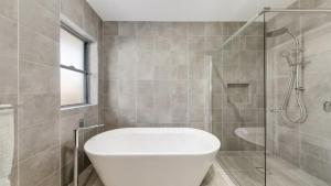 a bathroom with a toilet and a glass shower at Hunter Valley Wildflower in Pokolbin