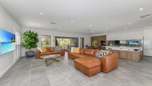a living room with leather furniture and a kitchen at Hunter Valley Wildflower in Pokolbin +11 photos