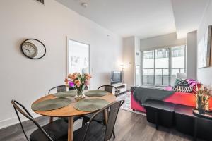 a living room with a table and chairs and a couch at 660sqf Condo by Lake close to Airport, Parking! in Toronto