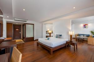 Baan Laimai Beach Resort & Spa - SHA Extra Plus في شاطيء باتونغ: غرفة نوم بسرير كبير وغرفة معيشة