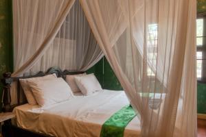a bedroom with a bed with a canopy at Bee Friend Boutique Guesthouse in Chiang Mai
