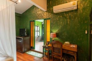 a room with a desk and a green wall at Bee Friend Boutique Guesthouse in Chiang Mai