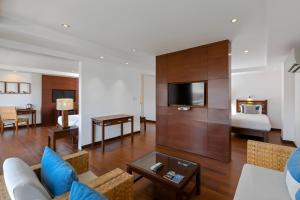 Baan Laimai Beach Resort & Spa - SHA Extra Plus في شاطيء باتونغ: غرفة معيشة مع أريكة وغرفة نوم