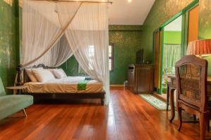 a bedroom with a canopy bed and green walls at Bee Friend Boutique Guesthouse in Chiang Mai