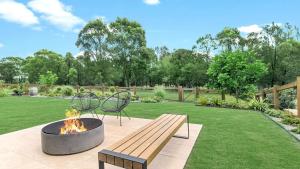 a fire pit and a bench in a park at Willow's Green in Pokolbin