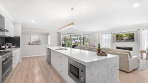 a kitchen and living room with a white counter top at D'Vine Cottage in Pokolbin