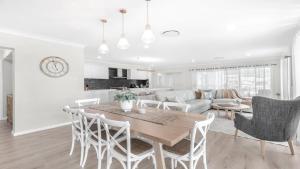 a dining room and living room with a table and chairs at D'Vine Cottage in Pokolbin