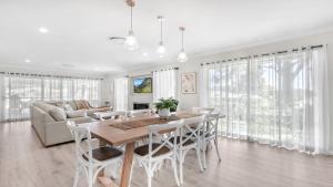 a dining room with a table and chairs and a couch at D'Vine Cottage in Pokolbin