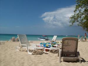 尼格瑞尔Studio Apt on 7 Mile Beach at Negril Beach Club的一群坐在海滩上的草坪椅