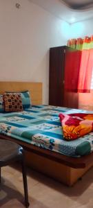 狄哈的住宿－Anjali Guest House，一间卧室配有一张带色彩缤纷的床单和枕头的床。