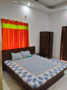 狄哈的住宿－Anjali Guest House，一间卧室配有一张带色彩缤纷窗帘的床