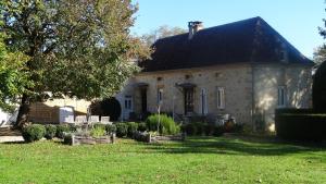una gran casa de piedra con un jardín delante de ella en Le Moulin Des Fumades, en Payrignac