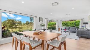 a living room with a wooden table and chairs at 21 Forever in Pokolbin