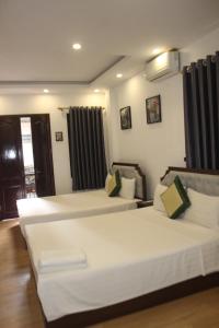 Dos camas en una habitación de hotel con dos en Hanoi Little Hotel, en Hanói