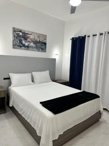 a bedroom with a large bed with a blue curtain at White Signature Suite in Kingston