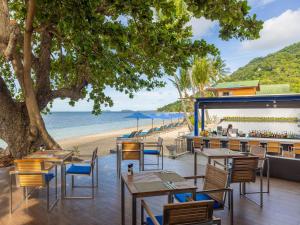a restaurant on the beach with tables and chairs at Explorar Koh Phangan - Adults Only Resort and Spa in Haad Rin