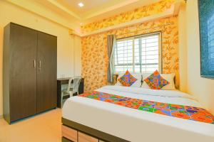a bedroom with a large bed and a window at GOLDEN LEAF PREMIUM HOTEL in Hinjewadi