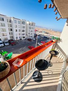 balcón con 2 taburetes y vistas a un aparcamiento en Departamento, en La Chimba