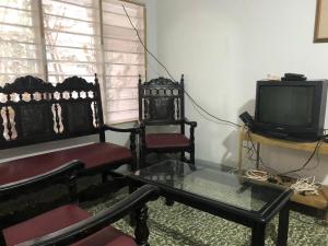 ein Wohnzimmer mit 2 Stühlen und einem TV in der Unterkunft Hostal Los Abuelos Colombianos in Cartagena de Indias