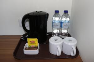 uma bandeja com duas chávenas e duas garrafas de água em Horison Sentani em Sentani