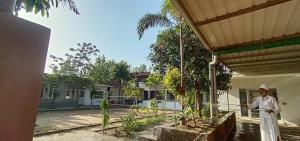 a nun standing in front of a building at Sir Mam Ashram in Bhaddi