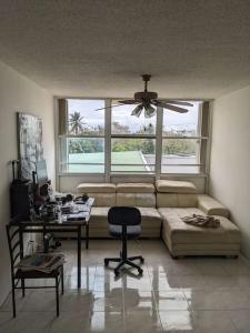 - un salon avec un canapé et une table avec un bureau dans l'établissement Spacious gated 2 bed 2 bath with pool, à San Juan