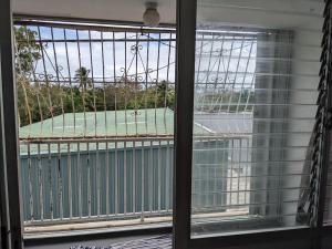 - une fenêtre donnant sur un court de tennis extérieur dans l'établissement Spacious gated 2 bed 2 bath with pool, à San Juan