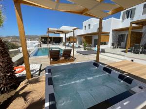 einen Pool mit Whirlpool in einem Haus in der Unterkunft CASA DI PIETRA MYKONOS in Klouvas