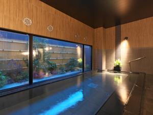 una piscina in un edificio con una grande finestra di Hotel Route Inn Kuwana a Kuwana