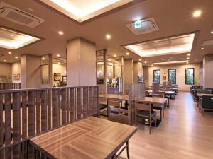 un ristorante con tavoli e sedie in legno e finestre di Hotel Route Inn Kuwana a Kuwana