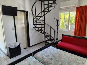 a living room with a red couch and a spiral staircase at CottonClub Villas in Tolo