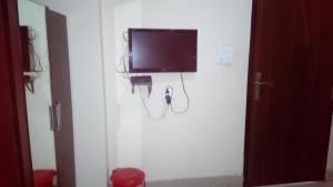 a tv on the wall of a room with at Hotel Sunshine in Kāshīpur