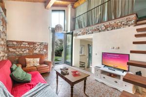 sala de estar con sofá rojo y TV en La Maison Du Lac - Happy Rentals, en  Monvalle 