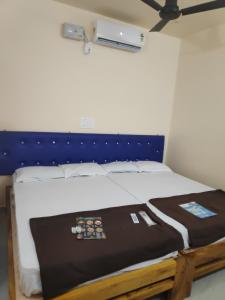 uma cama com uma cabeceira azul num quarto em Redkar Rooms Gokarna Beach front AC And Non AC Rooms em Gokarn