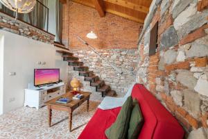sala de estar con sofá rojo y pared de ladrillo en La Maison Du Lac - Happy Rentals, en  Monvalle 