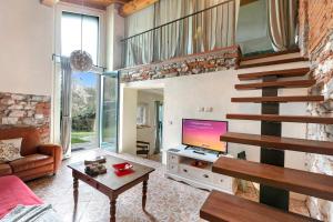 sala de estar con sofá, TV y escaleras en La Maison Du Lac - Happy Rentals, en  Monvalle 