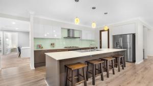 a kitchen with a island with bar stools at Alkira at The Vintage in Pokolbin