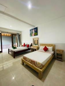 a bedroom with two beds and a couch at COCONUT BEACH BUNGALOWs & WARUNG in Amed