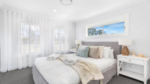 a white bedroom with a bed and windows at Montauk House in Pokolbin +16 photos